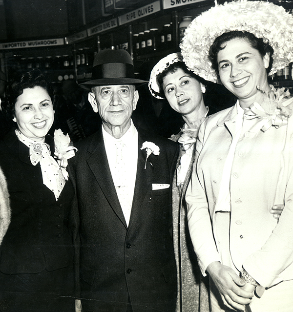 A black and white photo of an older man with three young women