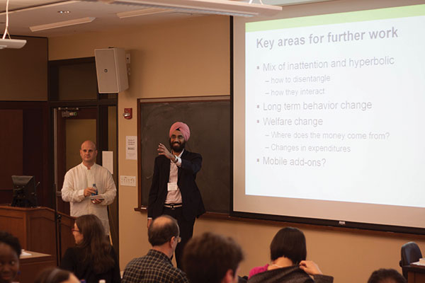 Singh giving a PowerPoint presentation in front of an audience