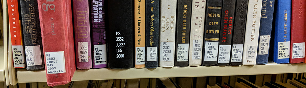 books on a shelf with call number labels showing
