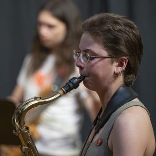 Student Sax player with guitarist in the background