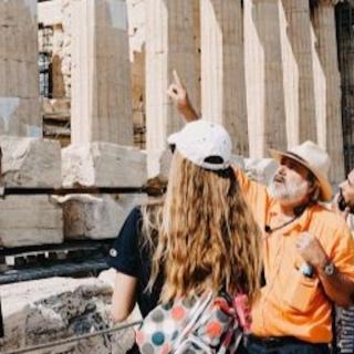 Faculty pointing and showing the acropolis of Athens to a group of students.