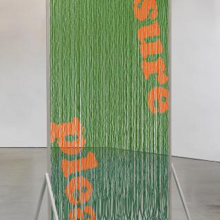 Green string hanging with orange string weaved in. Plea is spelled in the bottom left with Sure spelled in the top right.