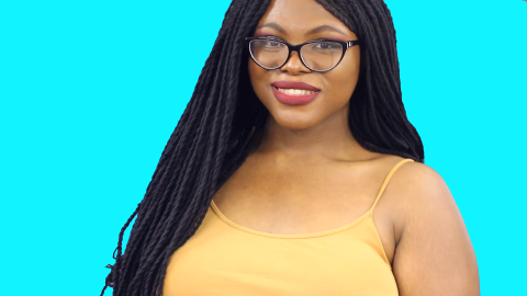 An image of Kat Blaque in a yellow tank top over a light blue background.