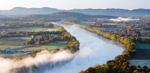 Aerial view of the Connecticut River Valley with mountains in the distance.