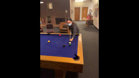 Me playing pool at a blue pool table in a common room in Moore
