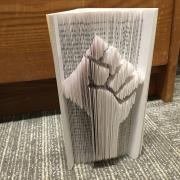 A photo of my book that I sculpted. A fist of solidarity is cut into the pages.